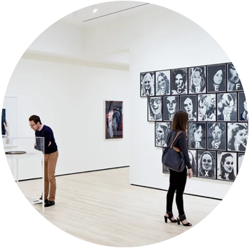 A light skinned white man and woman look at photography displays at an exhibit at the SF MOMA.