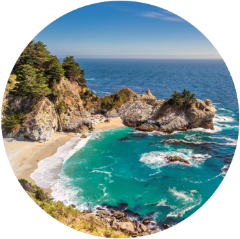 Waves flow out from an enclave surrounded by rock formations at Julia Pfeiffer Beach in the daytime.