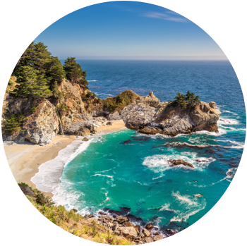 Waves flow out from an enclave surrounded by rock formations at Julia Pfeiffer Beach in the daytime.